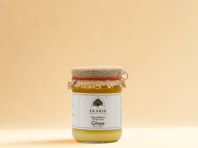 Ekaris Bilona Method A2 Gir Cow Ghee 500ml glass jar with jute cap on cream background
