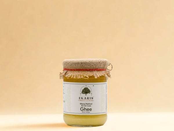 Ekaris Bilona Method A2 Gir Cow Ghee 500ml glass jar with jute cap on cream background