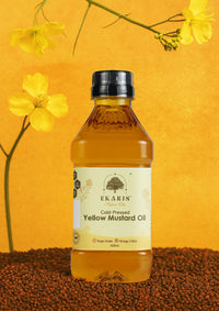 Ekaris Cold-Pressed Yellow Mustard Oil 500ml bottle with yellow mustard flowers on golden background