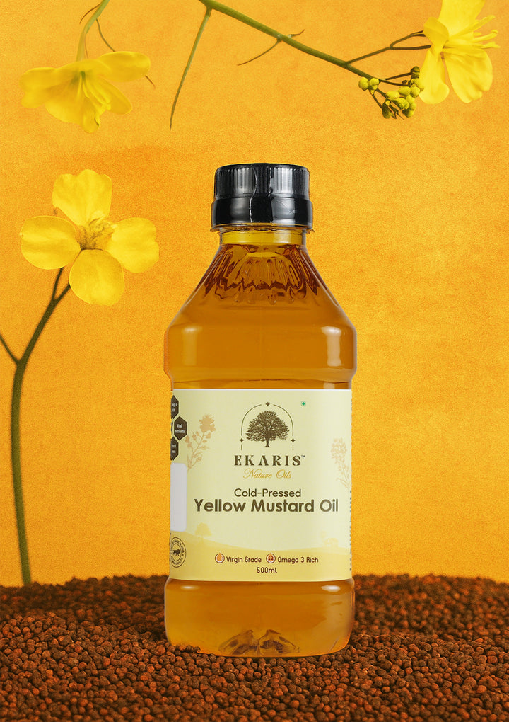 Ekaris Cold-Pressed Yellow Mustard Oil 500ml bottle with yellow mustard flowers on golden background